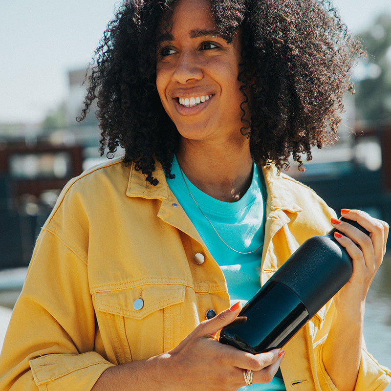 daily-on-the-go-set-l6 20oz_rise_classic_insulated_bottle_black_woman_smile_square.jpg