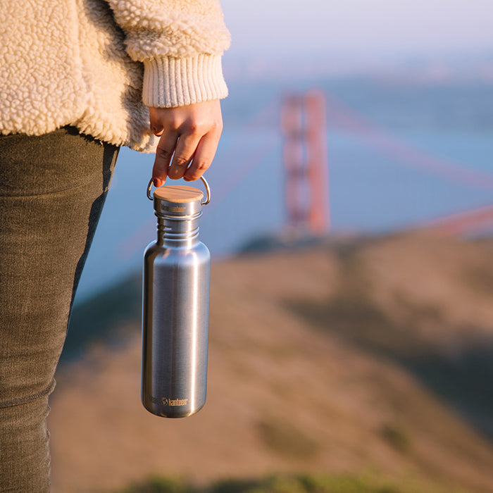 27oz-reflect-with-bamboo-cap-r9 K27SSLRF-BS-BAMBOO_reflect_bottle_bridge_lifestyle.jpg